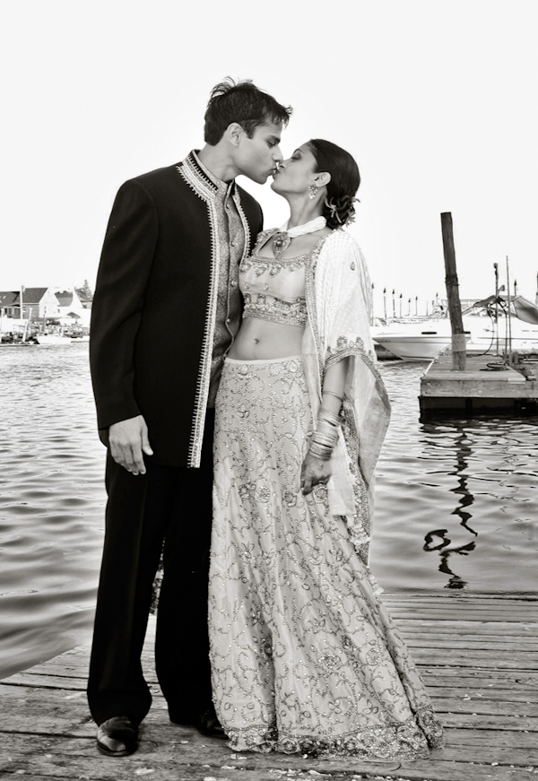 photo by New York based wedding photographer Merri Cry - the happy couple kissing on a dock - indian wedding
